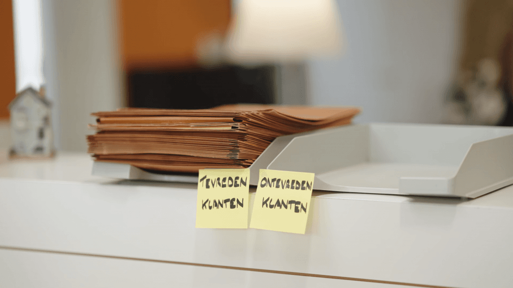 Stapel folders in bakje van tevreden klanten